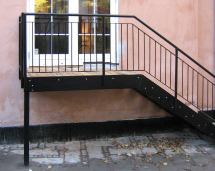 Udgangstrappe m. bred repos. Sortlakeret og med repos og trinbel�gning af massiv l�rketr�. 