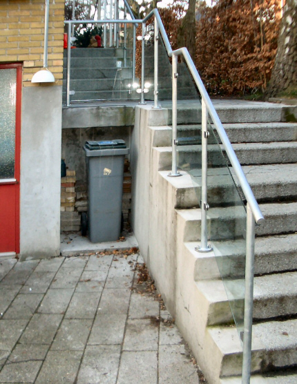 Trappegelnder af galvaniseret Stlrr 42,4mm, med rustfri glasbeslag der holder det faconskrne laminerede sikkerhedsglas, boltet p eksisterende trappetrin. 