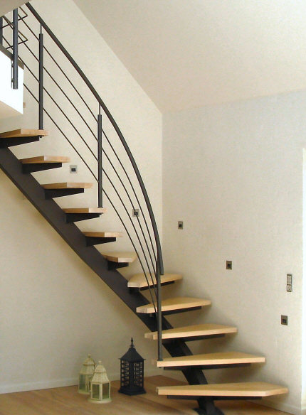 Opsadlet center ståltrappe: gelænderhåndliste, rækværk, balustre, medløbere og trappevange pulverlakeret i standard RAL farve, koksgrå.